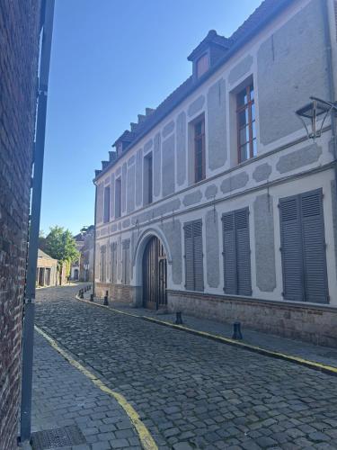 a large white building on a cobblestone street at La suite Isabelle de Luxembourg & Spa in Béthune