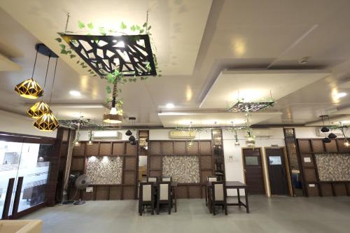 a room with chairs and tables in a room with lights at Hotel Shagun, Piplod City Centre Surat in Surat
