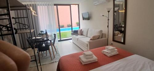 a bedroom with a bed and a living room at Sargaço Suíte Pool and Beach in Póvoa de Varzim