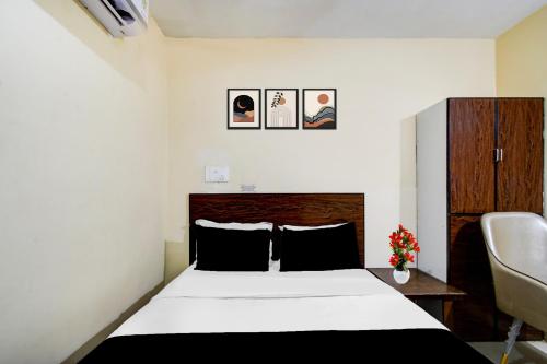 a bedroom with a bed with a black and white sheets at Super Collection O Isckon Temple Formerly Sri Varaahi Inn in Hyderabad