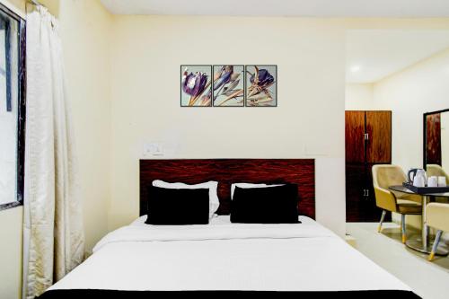 a bedroom with a bed and a table with chairs at Super Collection O Isckon Temple Formerly Sri Varaahi Inn in Hyderabad
