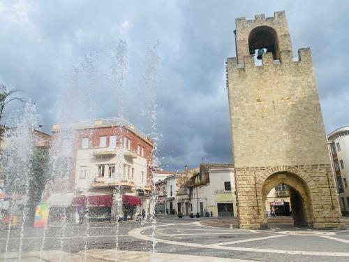 a fountain in front of a building with a tower at Casa Magnanina Sarda in Oristano