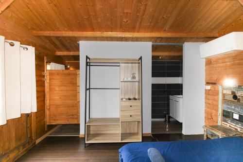 une pièce avec un réfrigérateur et des murs en bois dans l'établissement Le Chalet De La Plage, à Coti-Chiavari