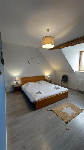 une chambre avec un grand lit dans un grenier dans l'établissement Gîte familial proche d'Amboise, à Souvigny-de-Touraine