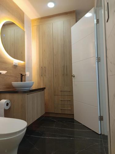 a bathroom with a toilet and a sink at El rincón de Valentina in Pelileo