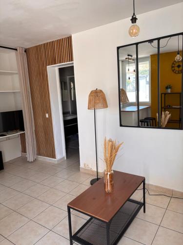 - un salon avec une table et un miroir dans l'établissement appartement cosi proche de tout, à Biarritz