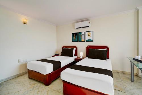 two beds in a hotel room with at Super Townhouse Civil Aviation HAL Road in Bengaluru