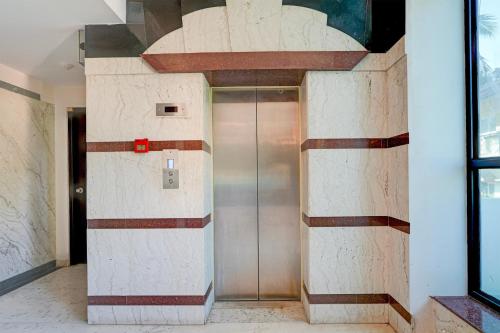a elevator with a metal door in a building at Super Townhouse Civil Aviation HAL Road in Bengaluru