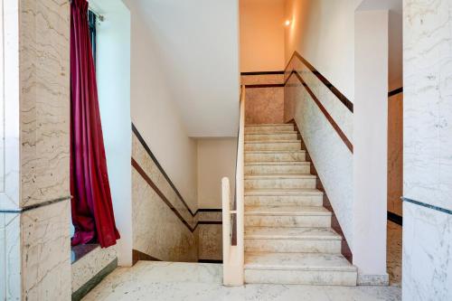 a staircase in a house with a red curtain at Super Townhouse Civil Aviation HAL Road in Bengaluru