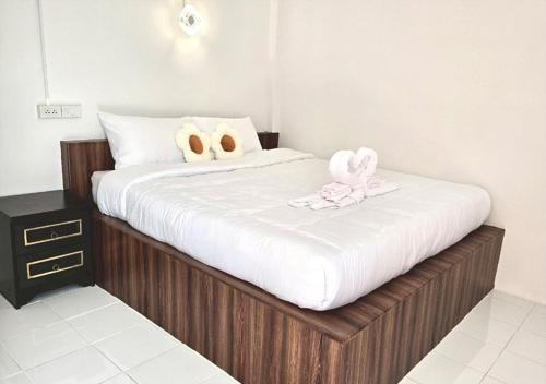 a bed with two stuffed animals on top of it at Route652 Resort Singburi in In Buri