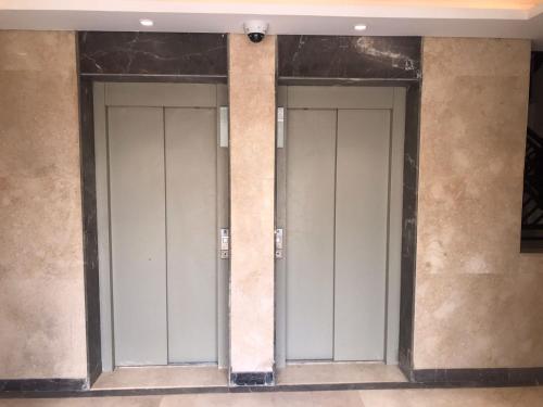 ein Türenpaar an einer Wand in einem Gebäude in der Unterkunft Apartment 160 m for rent, CELIA Compound TMG, direct on the green river, New Administration Capital in Madīnat al Amal