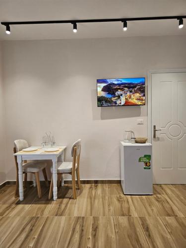 a dining room with a table and chairs and a painting on the wall at Star Room's in Durrës