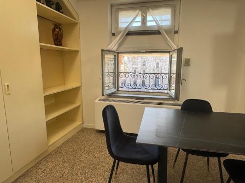 a dining room with a table and chairs and a window at Flat in Duomo in Milan