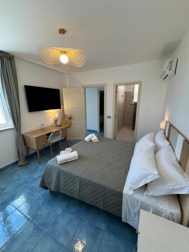 a bedroom with a bed and a desk and a television at Vento Verde Apartments in Sperlonga