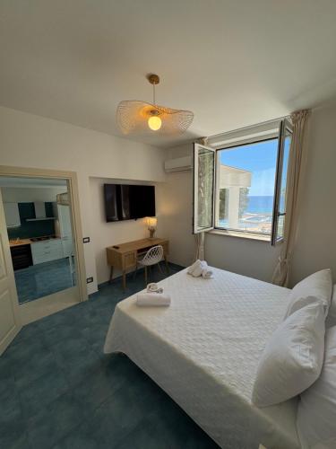 une chambre avec un grand lit et une fenêtre dans l'établissement Vento Verde Apartments, à Sperlonga