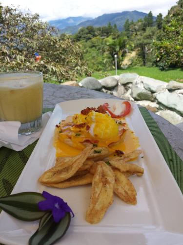 a plate of eggs and chips and a glass of juice at El Refugio La Brisa del Diablo in Valle Hornito