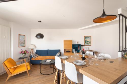 une salle à manger et un salon avec une table et des chaises dans l'établissement La Nacre - Vue Mer, à Erquy