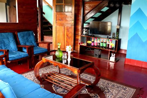a living room with a blue couch and a tv at DI Heritage in Kodaikānāl