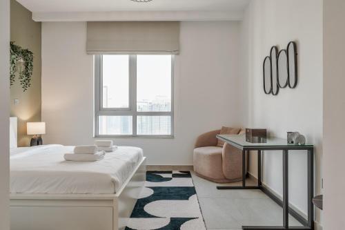 a bedroom with a bed and a couch and a chair at Prime Downtown 2BR Retreat in Dubai