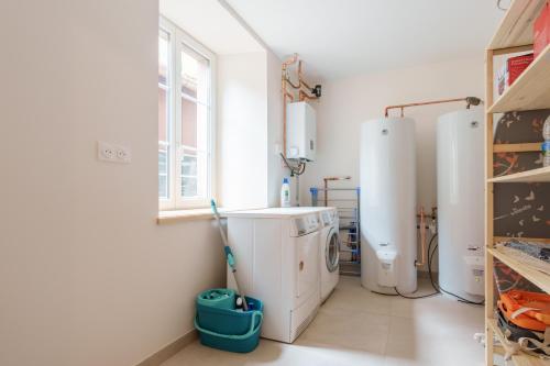 een wasruimte met een wasmachine en een raam bij Gîte de l'Oriel - Gîte avec Grand Jardin in Sainte-Marie-aux-Mines