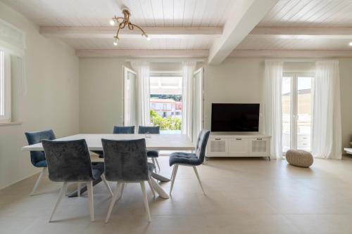 a dining room with a table and chairs and a tv at Parga Villas in Parga