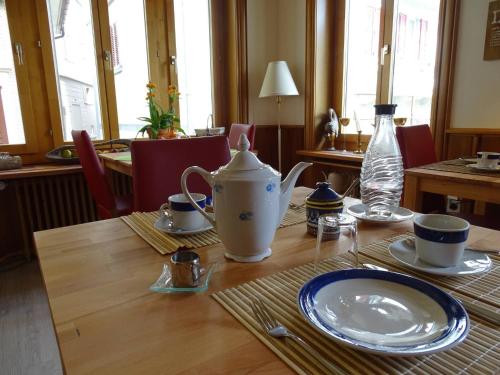 a table with a tea pot and plates on it at Organic BnB Froschknig Dorfplatz in Gersau