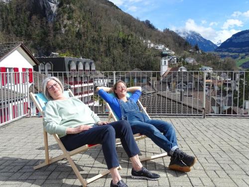 two women sitting in rocking chairs on a balcony at Organic BnB Froschkoenig Chaiserstock in Gersau