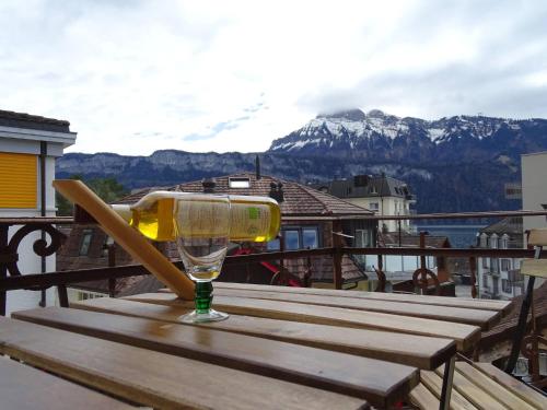 a wine glass sitting on a wooden table on a balcony at Organic BnB Froschknig Dorfplatz in Gersau