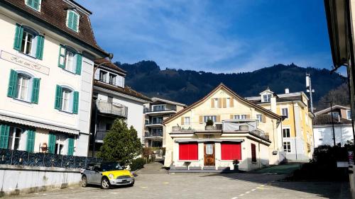 a small yellow car parked in front of some buildings at Organic BnB Froschkoenig Chaiserstock in Gersau