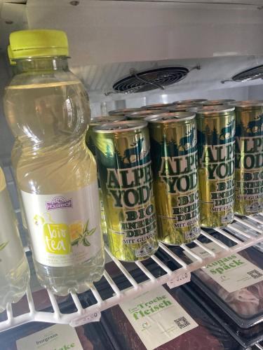 a shelf in a refrigerator with a bottle and cans of milk at Organic BnB Froschkoenig Chaiserstock in Gersau