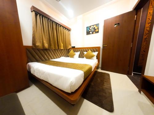 a bedroom with a large bed in a room at Hotel Narmada Palace in Ujjain