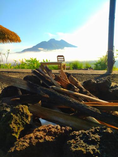 a pile of wood on the beach with a bench at Kintamani Adventure 'Hide Away In Kintamani in Kintamani