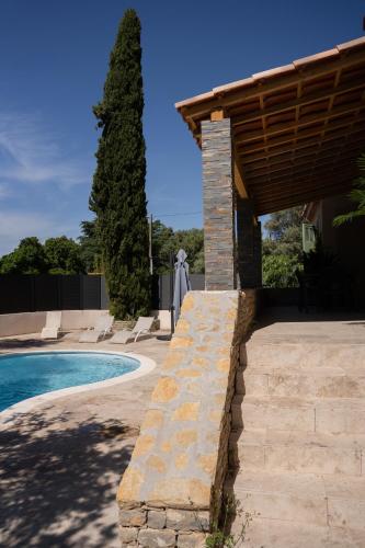 - une piscine avec une passerelle en pierre à côté d'une maison dans l'établissement Maison provençale, à Ceyreste