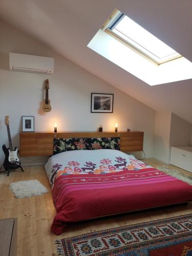 une chambre avec un grand lit avec une couverture rouge dans l'établissement Maison de charme, à 2 pas du centre ville de Valence - Drome, à Valence