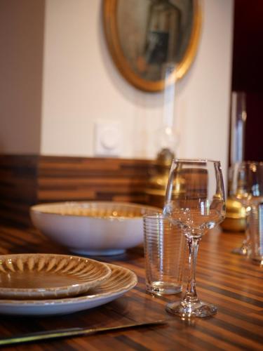 une table en bois avec des assiettes et des verres dans l'établissement Kuriosis - Central & Elegant, à Riom