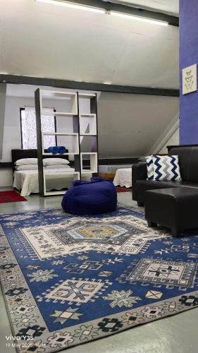 a living room with a blue rug and a couch at ROOMMATE On The ATTIC in Kuah