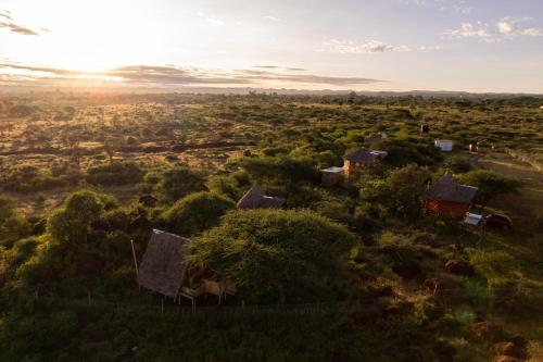 a group of houses on a hill at sunset at Olemayian Amboseli Cottages in Kimana