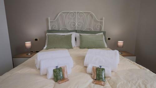 ein weißes Bett mit zwei Handtüchern und zwei Lampen in der Unterkunft Casa di Alice con parcheggio privato in Prato