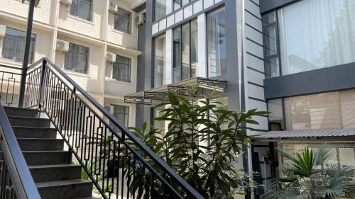a staircase leading to a building with plants at Chinor Hotel Fergana in Fergana
