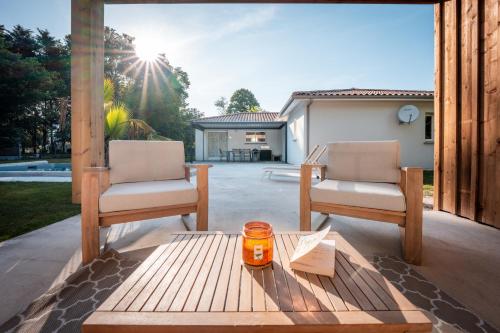 two chairs and a table on a patio at Maison entre Vignobles et Dune in Belin-Beliet