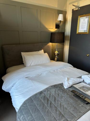 a large white bed sitting in a bedroom at The Q Hotel in Shanklin