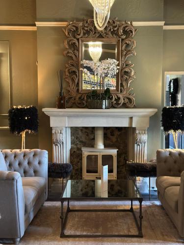 a living room with a fireplace and a table at The Q Hotel in Shanklin