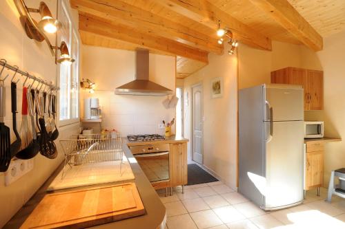 Il comprend une cuisine avec un réfrigérateur en acier inoxydable et des plafonds en bois. dans l'établissement GITE MADRES- CORONAT BALCON du CANIGOU, à Jujols