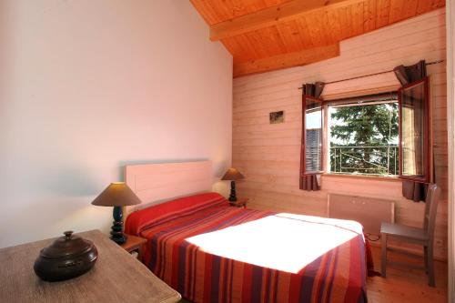 una camera da letto con un letto, un tavolo e una finestra di GITE MADRES- CORONAT BALCON du CANIGOU a Jujols