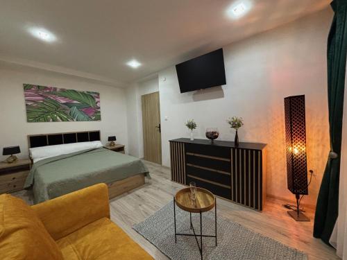 a bedroom with a bed and a tv on the wall at Emeraldia - quiet urban hideaway with modern style in Prievidza