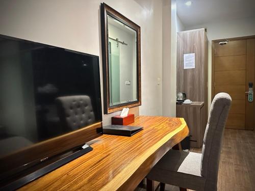 a wooden table with a large television on top of it at KEP BAY HOTEL & RESORT in Kep