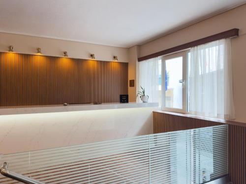 a bathroom with a tub and a large window at Anemoni Piraeus Hotel in Piraeus