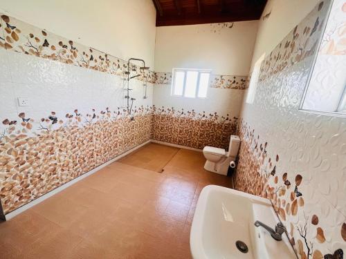 a bathroom with a toilet and a sink at Joytinat Yoga Ayurveda Villa in Kalkudah