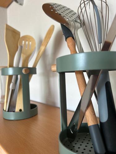a group of kitchen utensils in a holder on a counter at L'Erable T2 climatisé in Trébas
