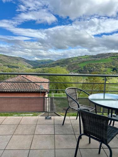 a patio with a table and chairs on a balcony at L'Erable T2 climatisé in Trébas